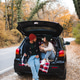 Romantic couple woman and man sitting in car trunk having picnic over nature autumn background. Romantic couple woman and man sitting in car trunk having picnic over nature autumn background. - PhotoDune Item for Sale