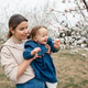 Smiling woman holding baby girl 1-2 year old wearing denim dress smelling flowers Smiling woman holding baby girl 1-2 year old wearing denim dress smelling flowers - PhotoDune Item for Sale