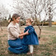 Stylish mother holding baby 1-2 year old girl wearing denim clothes outdoors Stylish mother holding baby 1-2 year old girl wearing denim clothes outdoors - PhotoDune Item for Sale