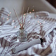 Home aroma liquid glass bottle diffuser with sticks on pajama shirt in bed with glowing lights. Home aroma liquid glass bottle diffuser with sticks on pajama shirt in bed with glowing lights. - PhotoDune Item for Sale