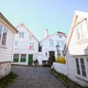 Historic white wooden houses on the cobblestone Mellomstraen street in the old town of Gamle Stavang Historic white wooden houses on the cobblestone Mellomstraen street in the old town of Gamle Stavang - PhotoDune Item for Sale