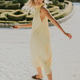 Woman twirls in a yellow dress at a garden during sunny weather Woman twirls in a yellow dress at a garden during sunny weather - PhotoDune Item for Sale