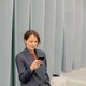 Woman using smartphone while standing near gray wall in urban setting Woman using smartphone while standing near gray wall in urban setting - PhotoDune Item for Sale
