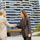 Women shake hands in front of modern building during a business meeting in the city Women shake hands in front of modern building during a business meeting in the city - PhotoDune Item for Sale