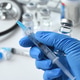 Holding syringe needle with generic vaccine booster shot Holding syringe needle with generic vaccine booster shot - PhotoDune Item for Sale