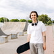Teenage skateboarder smiling at urban skate park Teenage skateboarder smiling at urban skate park - PhotoDune Item for Sale