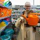 Woman holding a watering can, smiling while shopping for gardening supplies Woman holding a watering can, smiling while shopping for gardening supplies - PhotoDune Item for Sale