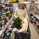 Woman pushing a shopping cart with plant and building materials in tool aisle Woman pushing a shopping cart with plant and building materials in tool aisle - PhotoDune Item for Sale