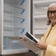 Smiling senior woman examining an empty refrigerator display in a retail store Smiling senior woman examining an empty refrigerator display in a retail store - PhotoDune Item for Sale