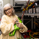 Senior woman smiling, holding a hedge trimmer in a hardware store aisle Senior woman smiling, holding a hedge trimmer in a hardware store aisle - PhotoDune Item for Sale
