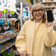 Senior woman smiling, holding smartphone with blank screen in a retail hardware store Senior woman smiling, holding smartphone with blank screen in a retail hardware store - PhotoDune Item for Sale