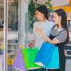 Two women are shopping in a store and pointing at the bags they are holding Two women are shopping in a store and pointing at the bags they are holding - PhotoDune Item for Sale