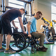 Professional sports trainer help disabled man in wheelchair move from exercise machine to wheelchair Professional sports trainer help disabled man in wheelchair move from exercise machine to wheelchair - PhotoDune Item for Sale