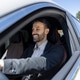 Stylish man smiling while driving modern car Stylish man smiling while driving modern car - PhotoDune Item for Sale