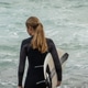 Female surfer holding surfboard looking at ocean waves from shore Female surfer holding surfboard looking at ocean waves from shore - PhotoDune Item for Sale