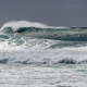Powerful surf break with large breaking waves under overcast sky Powerful surf break with large breaking waves under overcast sky - PhotoDune Item for Sale
