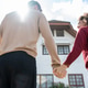 Rear view of Latino young couple walking in front of their new house. Rear view of Latino young couple walking in front of their new house. - PhotoDune Item for Sale