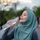 Asian Muslim woman drinking water while exercise on the rooftop garden. Asian Muslim woman drinking water while exercise on the rooftop garden. - PhotoDune Item for Sale