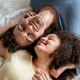 Latino young couple lying down together on bed in cozy bedroom at home. Latino young couple lying down together on bed in cozy bedroom at home. - PhotoDune Item for Sale