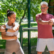 Senior man performing a shoulder mobility exercise alongside a fitness coach during an outdoor train Senior man performing a shoulder mobility exercise alongside a fitness coach during an outdoor train - PhotoDune Item for Sale