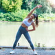 Athletic woman performing side bend stretch outdoors near water, improving flexibility, mobility and Athletic woman performing side bend stretch outdoors near water, improving flexibility, mobility and - PhotoDune Item for Sale