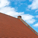 Red ceramic tiles covering roof under blue sky Red ceramic tiles covering roof under blue sky - PhotoDune Item for Sale