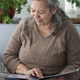 Mature Woman Looking Through a Family Photo Album at Home Mature Woman Looking Through a Family Photo Album at Home - PhotoDune Item for Sale
