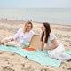 Two young women enjoying pizza picnic on sandy beach by calm sea Two young women enjoying pizza picnic on sandy beach by calm sea - PhotoDune Item for Sale