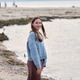 Young woman smiling by rocky seashore at dusk Young woman smiling by rocky seashore at dusk - PhotoDune Item for Sale
