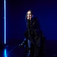 Young woman with long hair in black gothic outfit sitting on stool under blue neon light indoors Young woman with long hair in black gothic outfit sitting on stool under blue neon light indoors - PhotoDune Item for Sale
