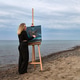 Adult female artist painting seascape on easel at serene beach under cloudy sky Adult female artist painting seascape on easel at serene beach under cloudy sky - PhotoDune Item for Sale