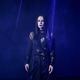 Young woman with gothic makeup and black outfit standing in dark room with blue light beams Young woman with gothic makeup and black outfit standing in dark room with blue light beams - PhotoDune Item for Sale