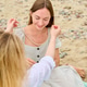 Woman receiving beaded necklace gift on Rocky Beach outdoors Woman receiving beaded necklace gift on Rocky Beach outdoors - PhotoDune Item for Sale