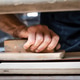 Close-up of Carpenter Sanding Wood Panel with Sanding Block Close-up of Carpenter Sanding Wood Panel with Sanding Block - PhotoDune Item for Sale