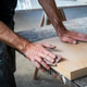 Carpenter Sanding Wood Panel Edge by Hand in Workshop Carpenter Sanding Wood Panel Edge by Hand in Workshop - PhotoDune Item for Sale