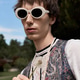 Stylish young man showcases unique summer fashion in a vibrant outdoor setting Stylish young man showcases unique summer fashion in a vibrant outdoor setting - PhotoDune Item for Sale