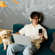 Young man creating music with his dog by his side in a modern recording studio Young man creating music with his dog by his side in a modern recording studio - PhotoDune Item for Sale