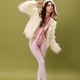 Trendy young model showcases faux fur jacket against olive green backdrop Trendy young model showcases faux fur jacket against olive green backdrop - PhotoDune Item for Sale