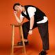 Stylish young man poses elegantly in vibrant orange studio setting Stylish young man poses elegantly in vibrant orange studio setting - PhotoDune Item for Sale