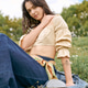 Young woman enjoying a sunny day in the park wearing fashionable and cozy attire Young woman enjoying a sunny day in the park wearing fashionable and cozy attire - PhotoDune Item for Sale