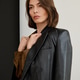 Confident woman exudes elegance in black leather jacket in bright room Confident woman exudes elegance in black leather jacket in bright room - PhotoDune Item for Sale
