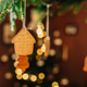 Christmas dinner table decoration, gingerbread cookie house hanging on ropes over table, close-up. Christmas dinner table decoration, gingerbread cookie house hanging on ropes over table, close-up. - PhotoDune Item for Sale