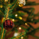 Glass round Christmas tree ornament and yellow garlands, close-up holiday decoration Glass round Christmas tree ornament and yellow garlands, close-up holiday decoration - PhotoDune Item for Sale
