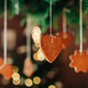 Christmas dinner table decoration, gingerbread cookie house hanging on ropes over table, close-up. Christmas dinner table decoration, gingerbread cookie house hanging on ropes over table, close-up. - PhotoDune Item for Sale