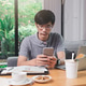 A man holding a smartphone in one corner of the home office. A man holding a smartphone in one corner of the home office. - PhotoDune Item for Sale