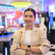 Smiling young Thai Isan businesswoman with crossed arms standing in an arcade room Smiling young Thai Isan businesswoman with crossed arms standing in an arcade room - PhotoDune Item for Sale