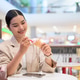 Smiling young Thai Isan businesswoman enjoying an ice cream cone at a cafe Smiling young Thai Isan businesswoman enjoying an ice cream cone at a cafe - PhotoDune Item for Sale