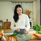 Young Woman Chopping Fresh Kale in a Modern Home Kitchen with Colorful Vegetables and Fruits Young Woman Chopping Fresh Kale in a Modern Home Kitchen with Colorful Vegetables and Fruits - PhotoDune Item for Sale