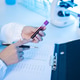 Laboratory Technician Holding Blood Sample Test Tube While Recording Results on Clipboard in Medical Laboratory Technician Holding Blood Sample Test Tube While Recording Results on Clipboard in Medical - PhotoDune Item for Sale