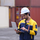 Industrial freight operator managing cargo transport operations with laptop at shipping container ya Industrial freight operator managing cargo transport operations with laptop at shipping container ya - PhotoDune Item for Sale